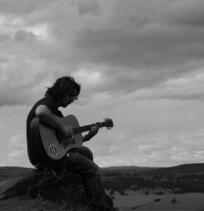black and white person playing guitar